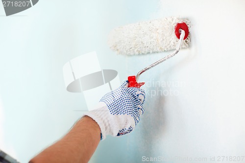 Image of close up of male in gloves painting wall