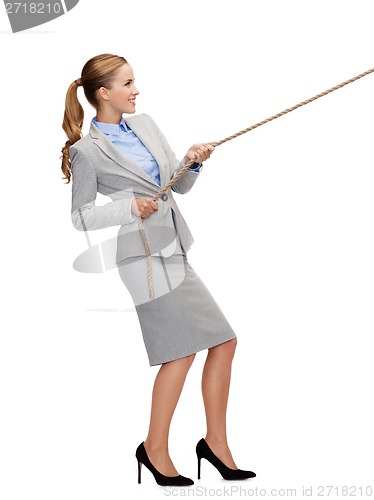 Image of smiling businesswoman pulling rope