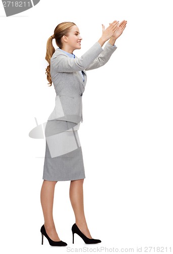 Image of smiling businesswoman holding something imaginary