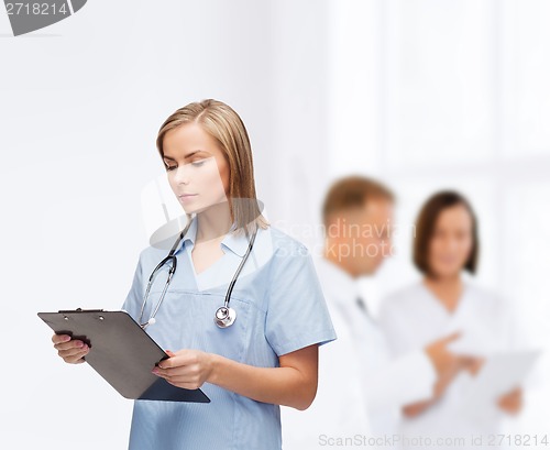 Image of smiling female doctor or nurse with clipboard