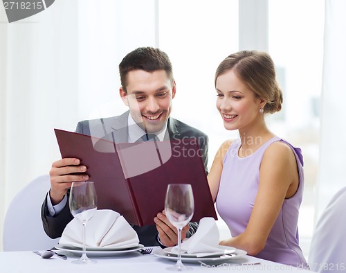 Image of smiling couple with menu at restaurant