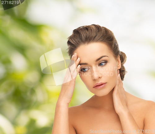 Image of woman holding hands on her neck and forehead