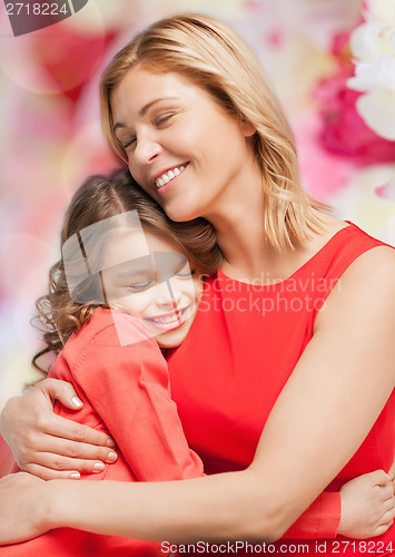 Image of smiling mother and daughter hugging