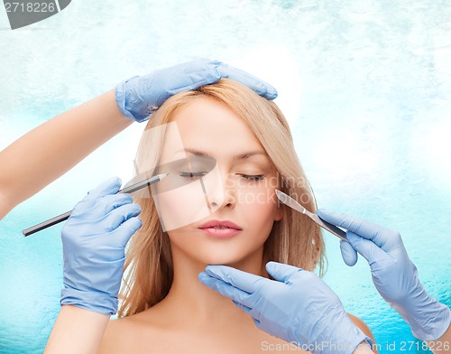 Image of woman and beautician hands with pencil and scalpel