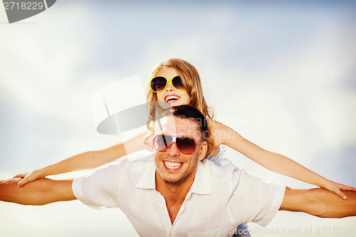 Image of happy father and child in sunglasses over blue sky