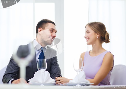 Image of smiling couple looking at each other at restaurant