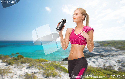 Image of sporty woman drinking water from sportsman bottle