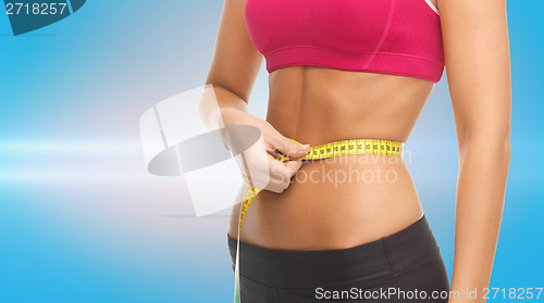 Image of close up trained belly with measuring tape