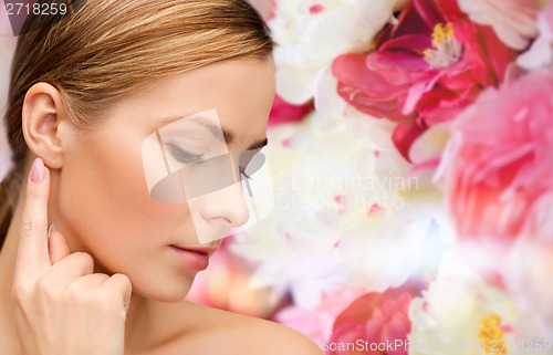 Image of calm woman touching her ear