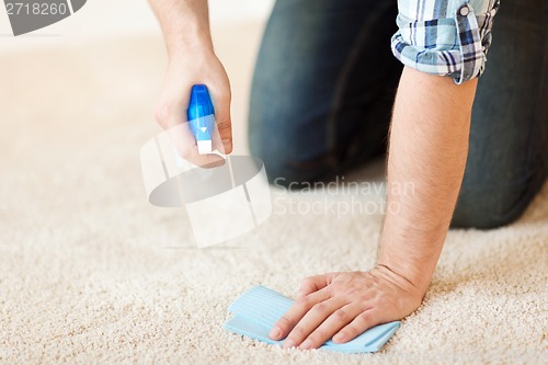 Image of close up of male cleaning stain on carpet