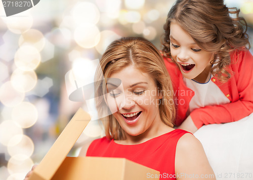 Image of smiling mother and daughter with gift box