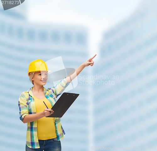 Image of smiling woman in helmet with clipboard