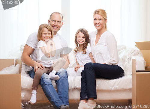 Image of smiling parents and two little girls at new home