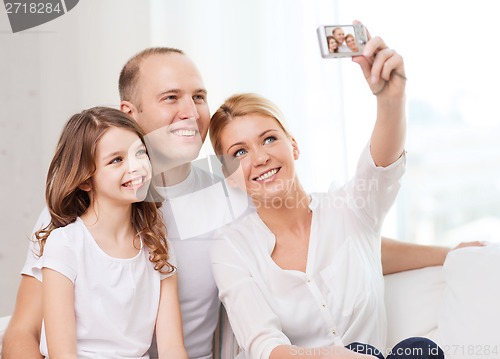 Image of happy family with little girl making self portrait