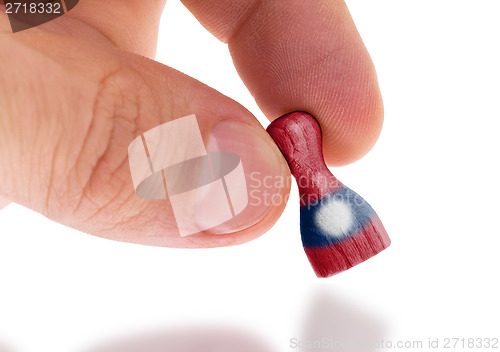 Image of Wooden pawn with a painting of a flag