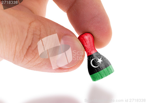 Image of Wooden pawn with a painting of a flag