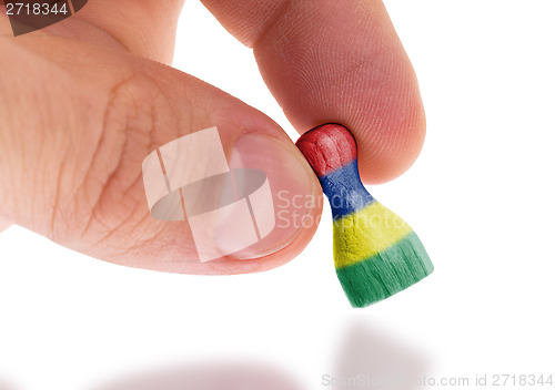 Image of Wooden pawn with a painting of a flag