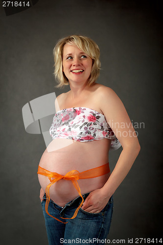 Image of beautiful pregnant woman tenderly holding her tummy