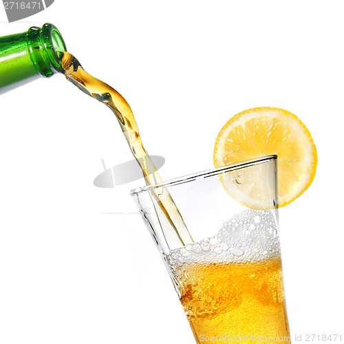 Image of Beer pouring from bottle into glass with lemon isolated on white