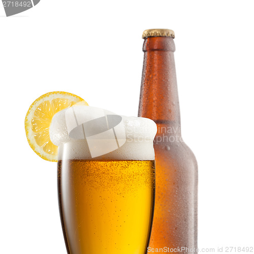 Image of Beer in glass with lemon and bottle isolated on white