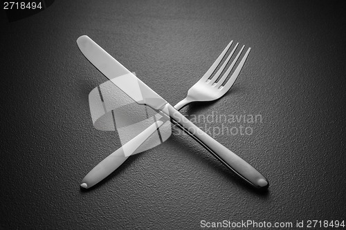 Image of crossed knife and fork on black