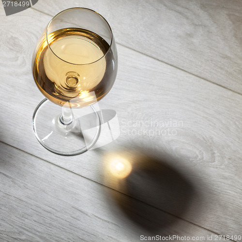 Image of Glass of white wine on wooden table. Top view