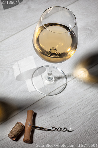 Image of Glass of white wine on wooden table. Top view