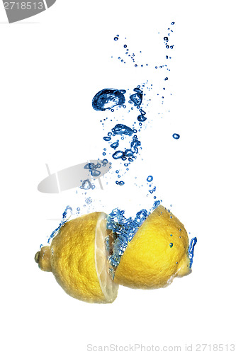 Image of Fresh lemon dropped into water with bubbles isolated on white