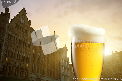 Image of Glass of beer against silhouettes of houses in Bruges, Belgium