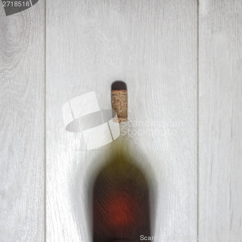 Image of Bottle of red wine with cork on white wooden table. Top view