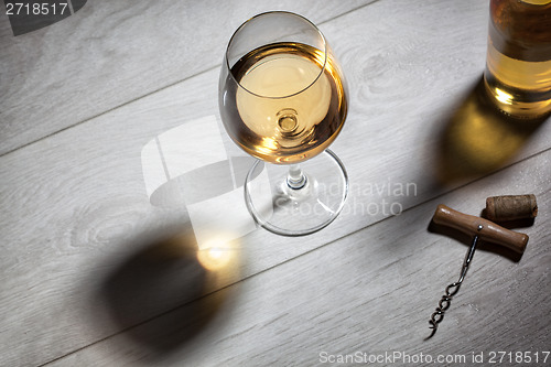 Image of Glass of white wine on wooden table. Top view