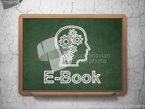 Image of Education concept: Head With Gears and E-Book on chalkboard background