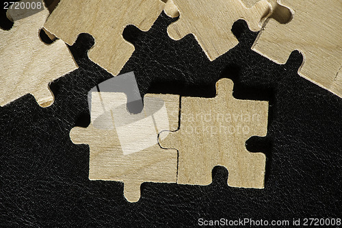 Image of Wooden puzzle on black background