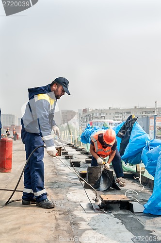 Image of Workers make waterproofing of seams on the bridge