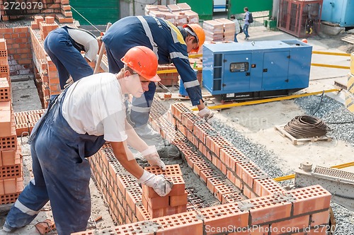 Image of Team of bricklayers on house construction