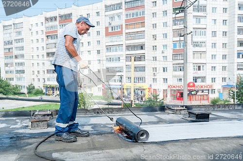 Image of Worker make waterproofing of seams on the bridge