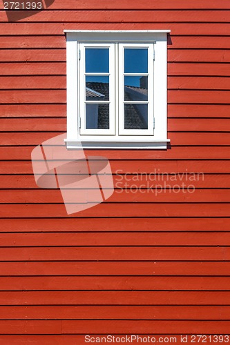 Image of White wooden window on the red wooden house wall