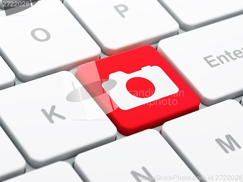 Image of Tourism concept: Photo Camera on computer keyboard background
