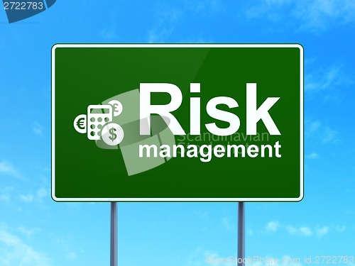 Image of Finance concept: Risk Management and Calculator on road sign background