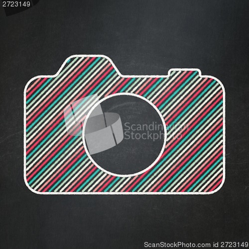 Image of Travel concept: Photo Camera on chalkboard background