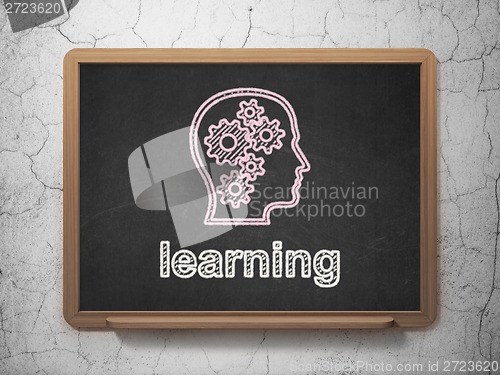 Image of Education concept: Head With Gears and Learning on chalkboard background