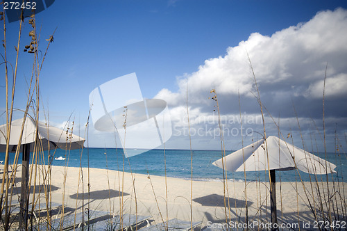 Image of beautiful beach with lounge chairs and blue sky