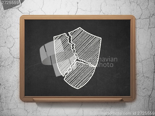 Image of Protection concept: Broken Shield on chalkboard background