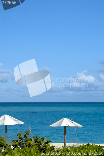 Image of ocean beach with chairs umbrellas