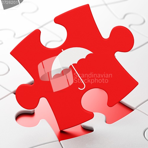 Image of Protection concept: Umbrella on puzzle background