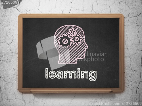 Image of Education concept: Head With Gears and Learning on chalkboard background