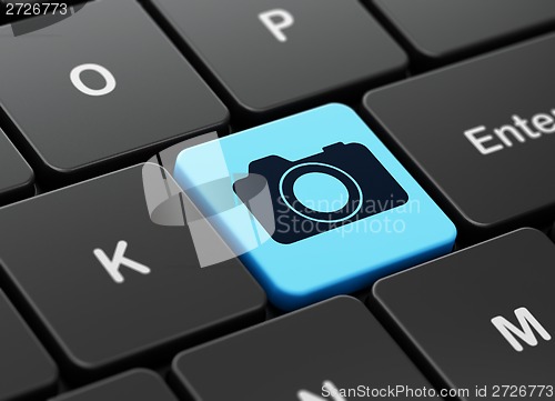 Image of Vacation concept: Photo Camera on computer keyboard background