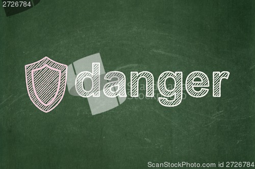 Image of Protection concept: Shield and Danger on chalkboard background