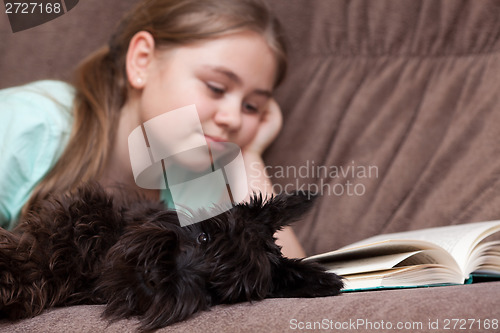 Image of Dog and little girl on the sofa