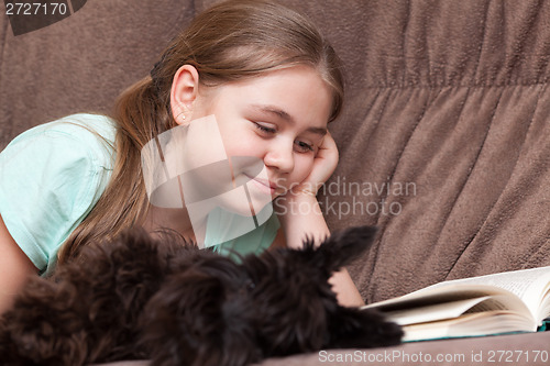 Image of Little girl with a book and dog